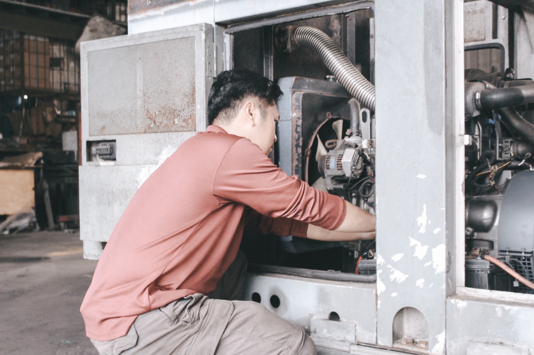 A Dyna technician servicing the engine of a generator set in the workshop