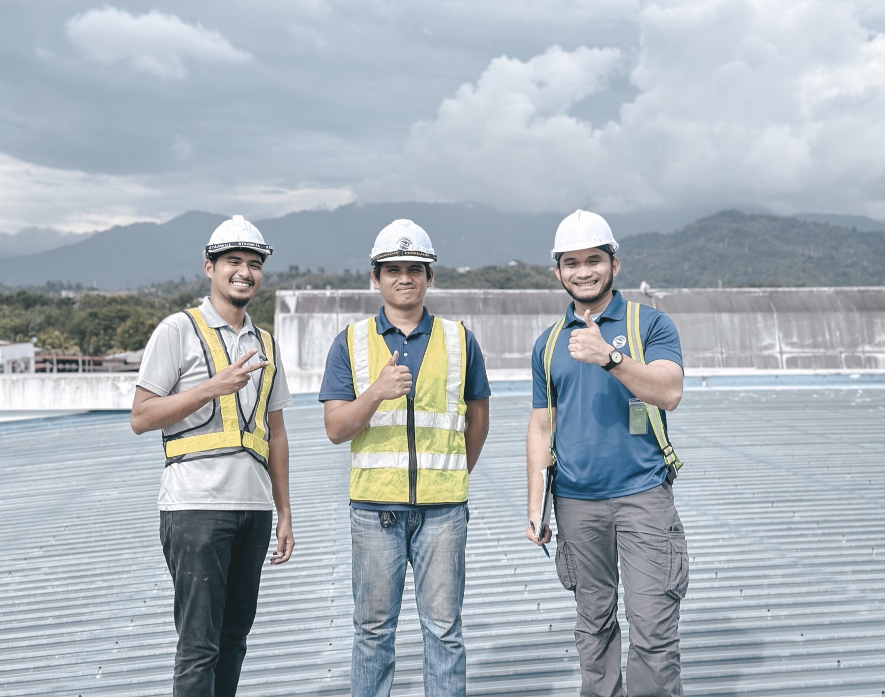 Three Dyna engineers on a factory rooftop during a site survey